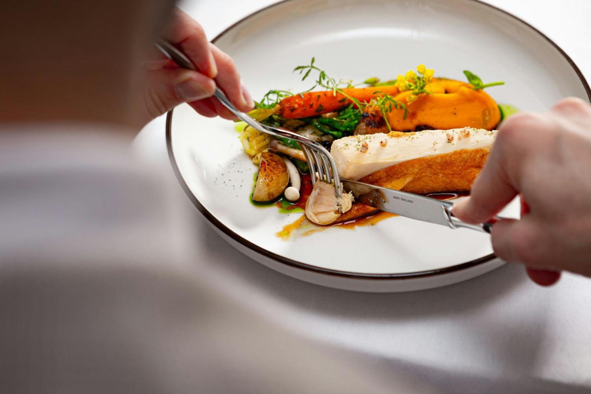 Grand Hotel River Park, A Luxury Collection Hotel, Bratislava Eksteriør billede A person using a knife and fork to cut into a meal